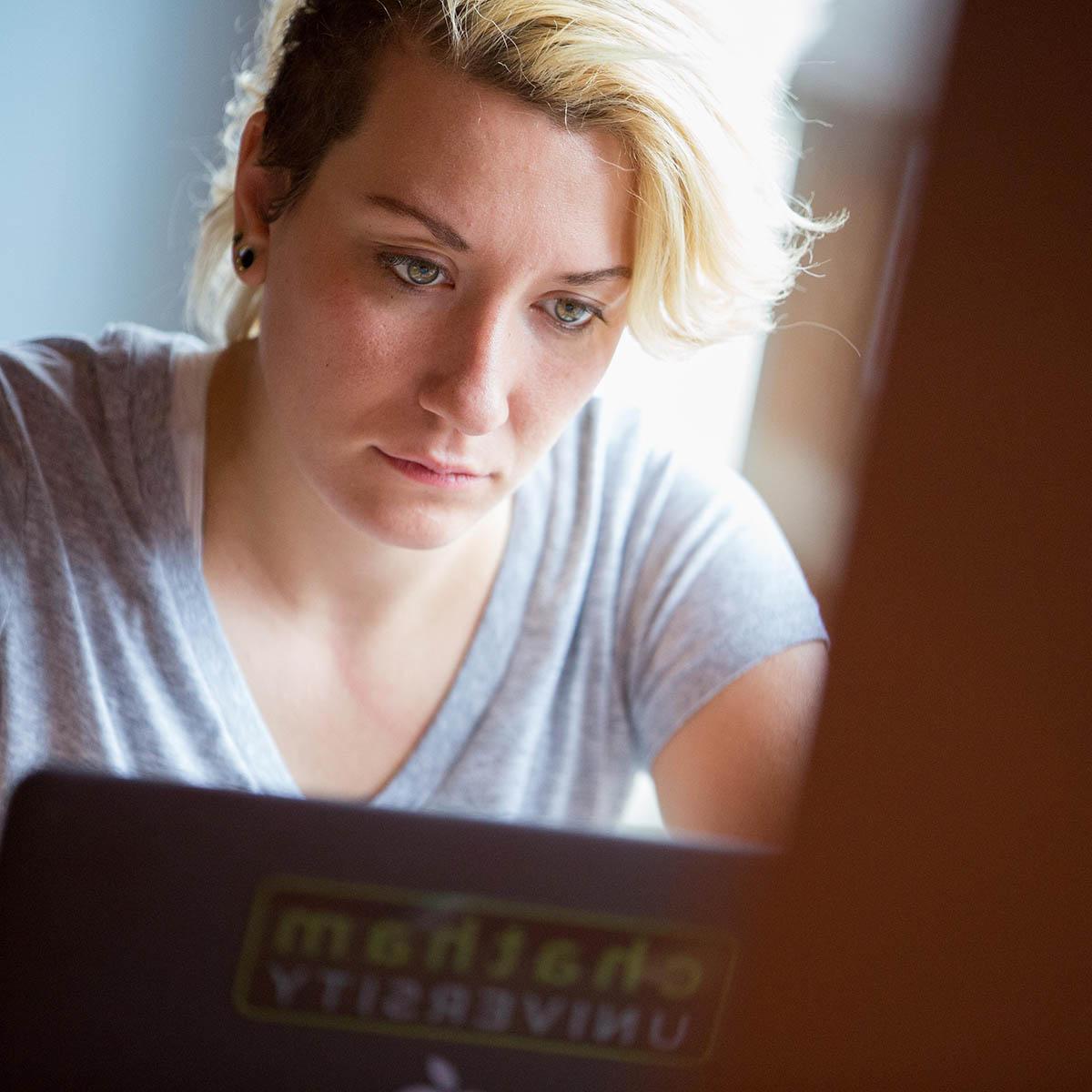 A student works on her laptop at a cafe table