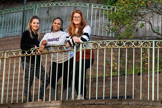 Photo of three Chatham University graduate students posing for a photo at the front gates of  Vincentian Schenley Gardens